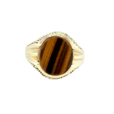 Gold ring with a tiger's eye stone on a white background